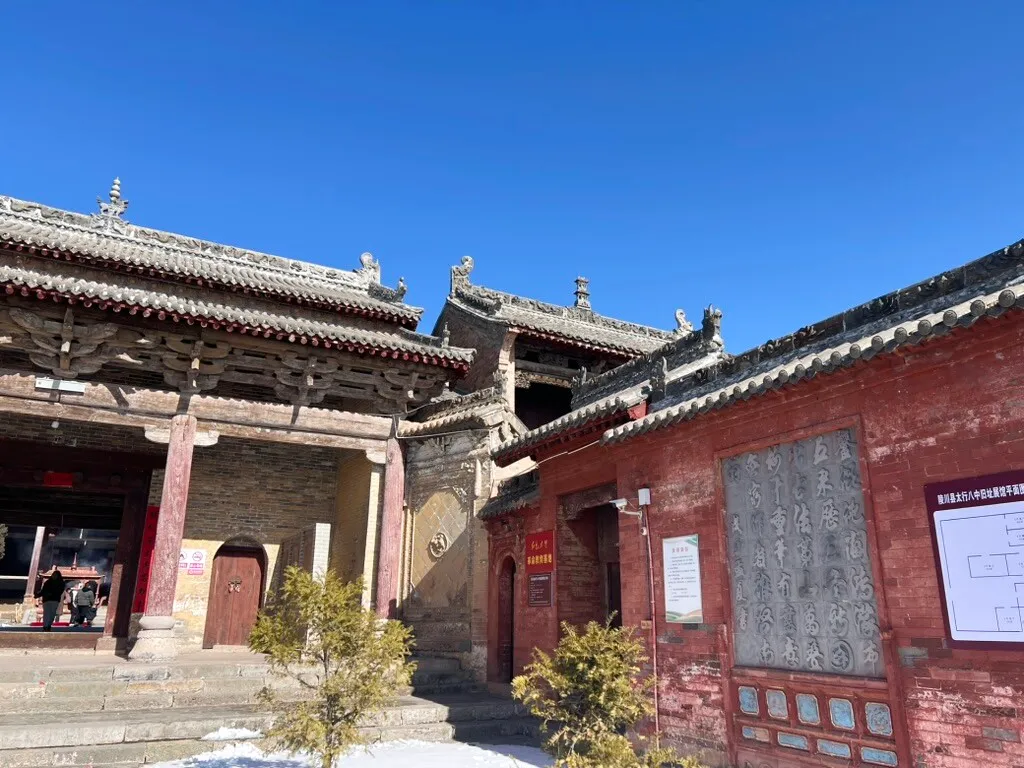 院内一侧，左边是殿宇前廊，右边是砖墙上嵌着书法石刻的配房